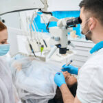 Dentist performing root canal procedure on patient in dental clinic
